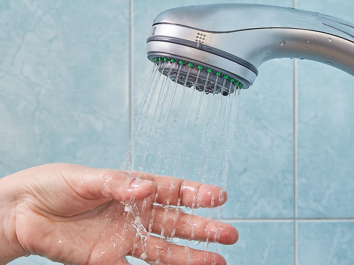 Hand under clean shower water.